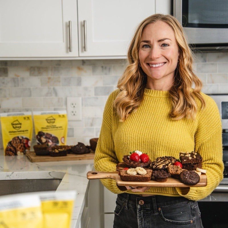 The founder of Beanie Bites holding a board of her baked treats