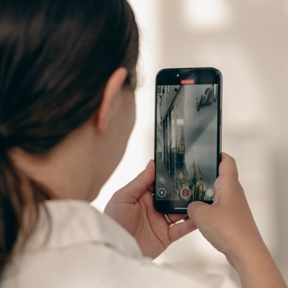 Filming a Sarasota storefront on a phone during a Siesta Media shoot